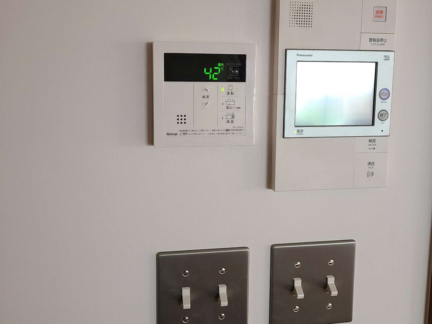 壁に取り付けたスイッチとインターホンの親機